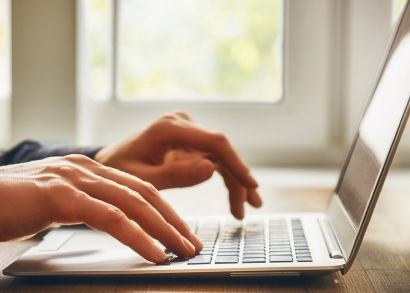 hands typing on laptop keyboard