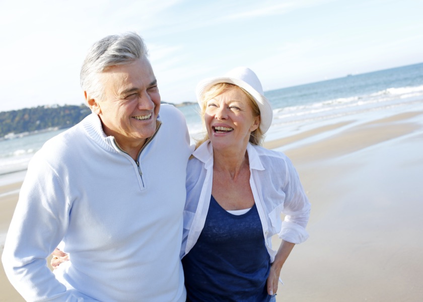 older couple on beach smiling