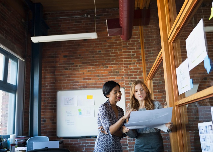 two business women looking at plans 